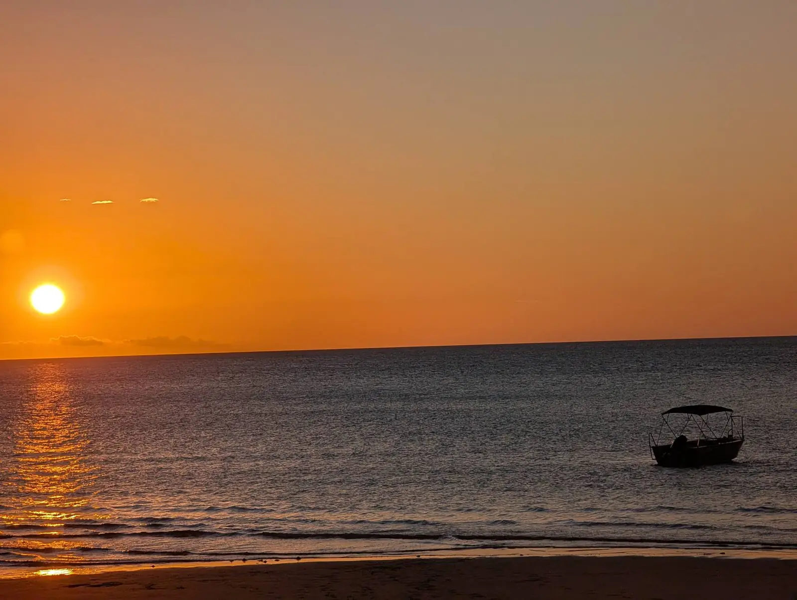 Sunset over the Torres Strait with a dinghy on the water